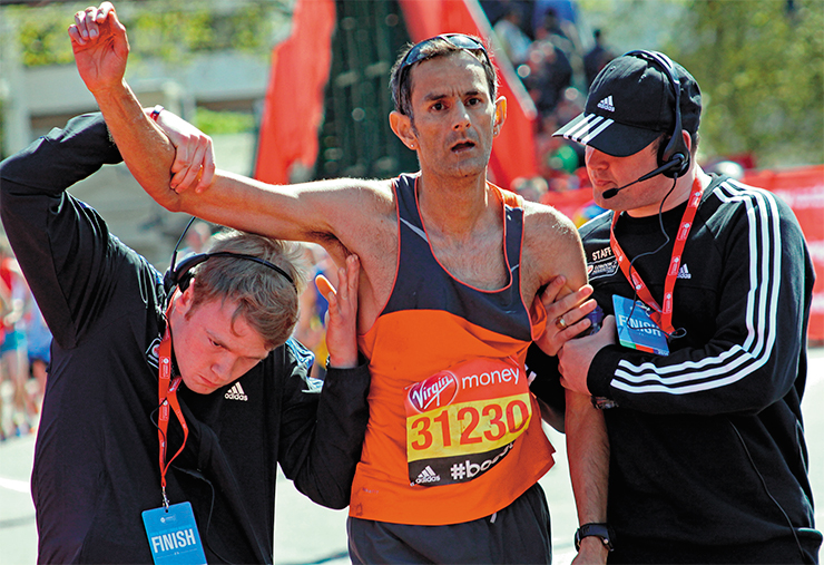 Участник Лондонского марафона (Virgin London Marathon) Джон Сандху, столкнувшийся с «марафонской стеной», одолел последние несколько метров до финиша с помощью официальных помощников. 2014 г. © Dave Smith 1965