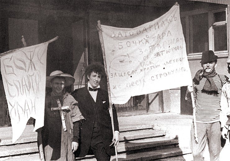 Первый студенческий карнавал НГУ. На плакате – цитата из только что опубликованной книги В. Аксенова «Затоваренная бочкотара». 1968 г. На фото: слева направо – О. Лопатин, П. Бородин, А. Осадчук