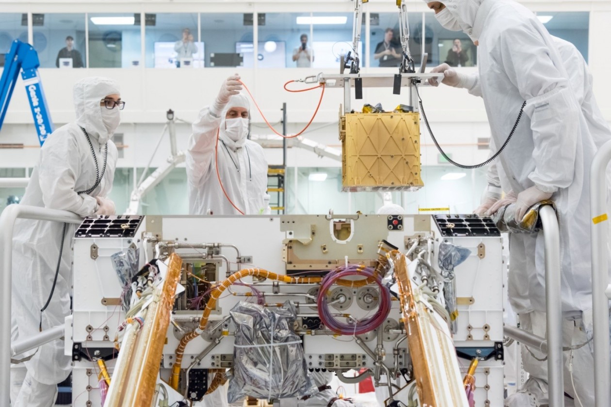 Специалисты осторожно помещают прибор MOXIE внутрь марсохода Perseverance. © NASA/JPL-Caltech Специалисты осторожно помещают прибор MOXIE внутрь марсохода Perseverance. © NASA/JPL-Caltech