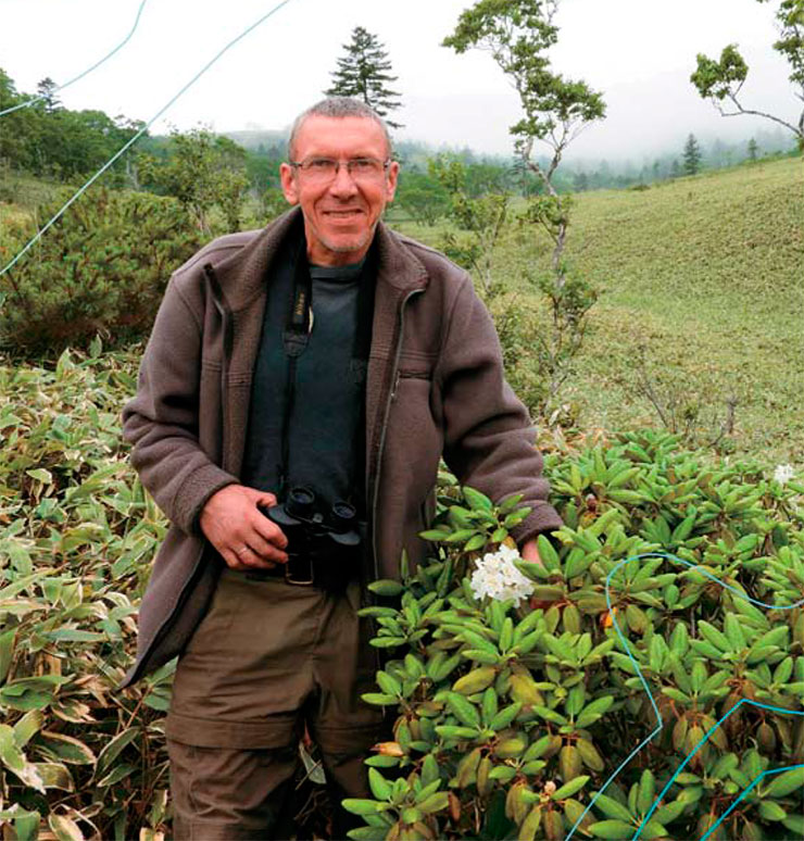 In July of 2018, the white flowers of the Kunashir rhododendron bloomed again. A. A. Kisleyko, the director of the nature reserve since 2015, is posing next to the rare plant In July of 2018, the white flowers of the Kunashir rhododendron bloomed again. A. A. Kisleyko, the director of the nature reserve since 2015, is posing next to the rare plant