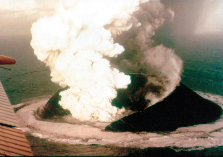On November 14, 1963 a black column of volcanic ash heralded the birth of an island on the southern coast of Iceland. The eruption started 130 m below the sea level and continued until the volcano’s height reached the sea surface. The photo shows a 16-day volcanic cone. Photo by H. Williams On November 14, 1963 a black column of volcanic ash heralded the birth of an island on the southern coast of Iceland. The eruption started 130 m below the sea level and continued until the volcano’s height reached the sea surface. The photo shows a 16-day volcanic cone. Photo by H. Williams