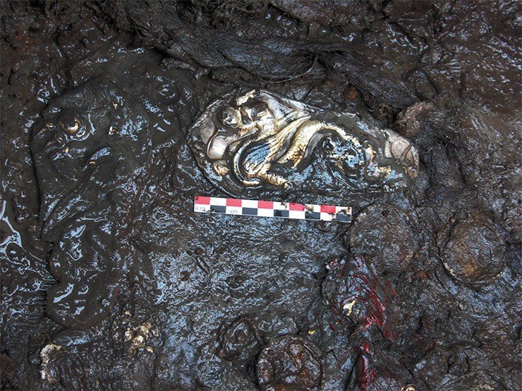 На полу погребальной камеры: бляха с драконами и другие украшения, пока еще затянутые глиной